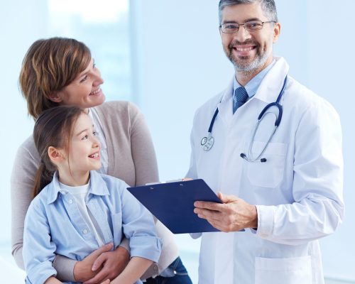 Cute girl and her mother looking at the doctor in hospital